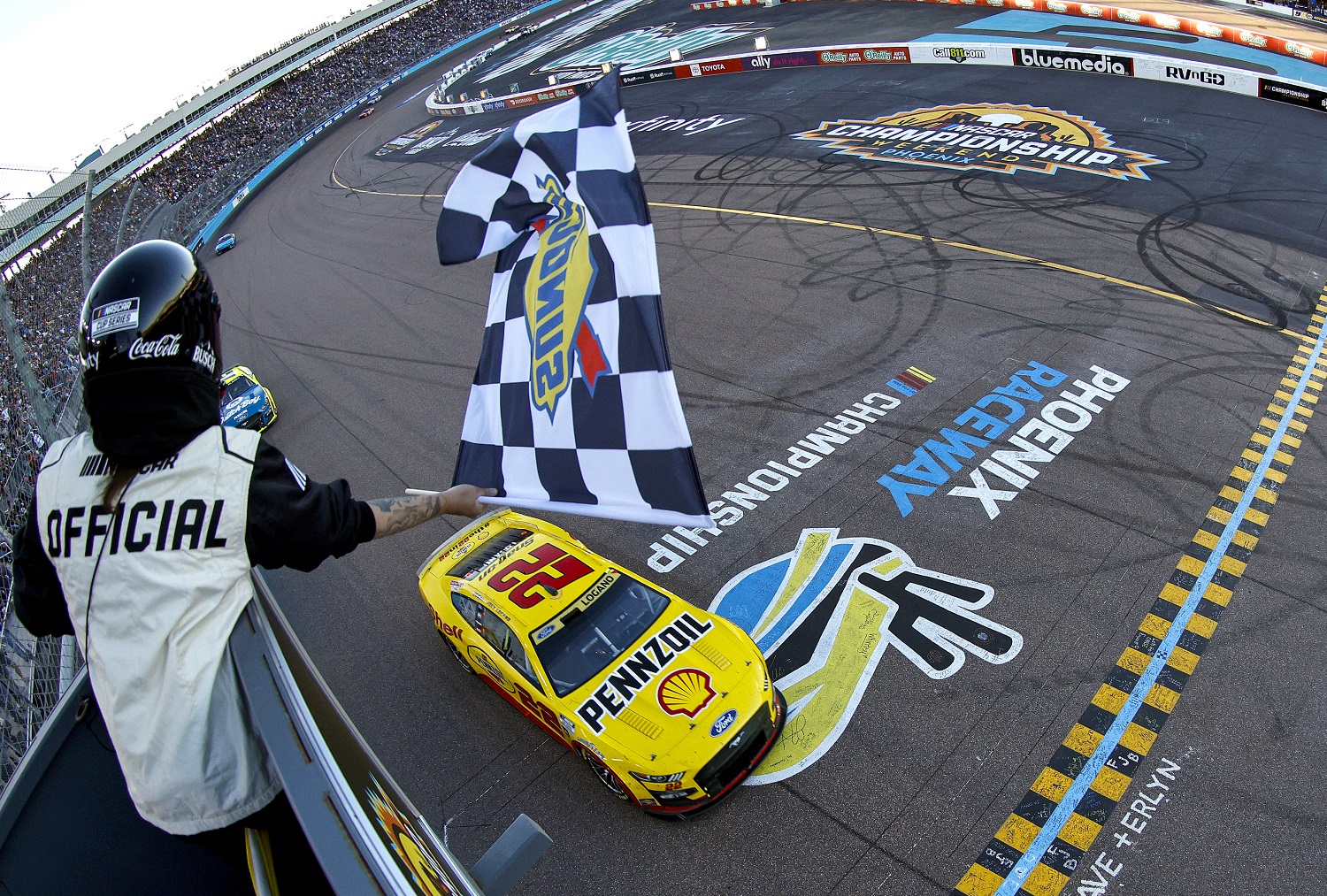 Joey Logano takes the checkered flag to win the 2022 NASCAR Cup Series Championship at Phoenix Raceway on Nov. 6, 2022.