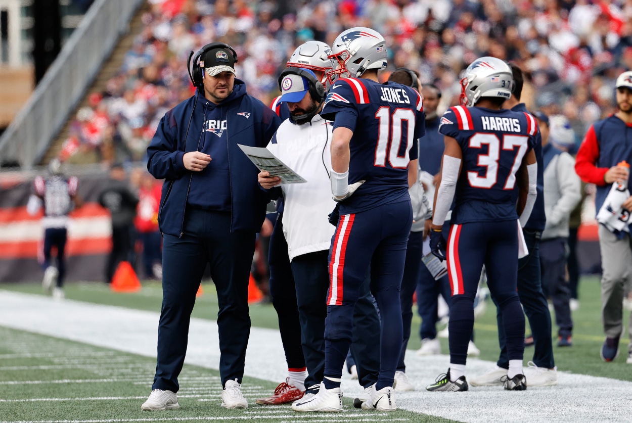 New England Patriots offensive assistant/ quarterbacks coach Joe Judge, senior football advisor/ offensive line coach Matt Patricia, and quarterback Mac Jones talk during a game between the New England Patriots and the Miami Dolphins.