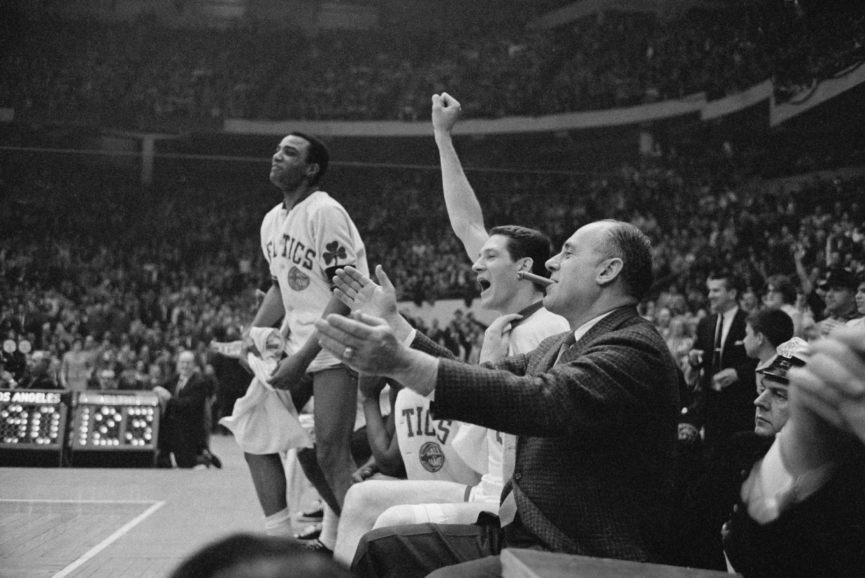 Boston Celtics coach Red Auerbach with basketball players John Havlicek, center, and Willie Naulls celebrate against the Los Angeles Lakers.