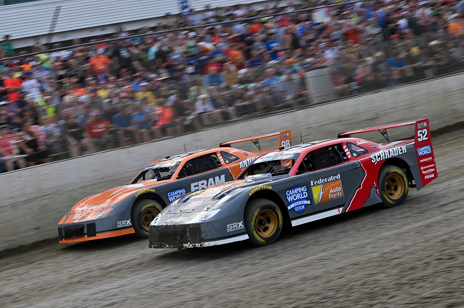 Ken Schrader, driver of No. 52, and Marco Andretti, driver of No. 98, compete in a heat race at a Camping World Superstar Racing Experience at I-55 Raceway on July 16, 2022 in Pevely, Missouri.