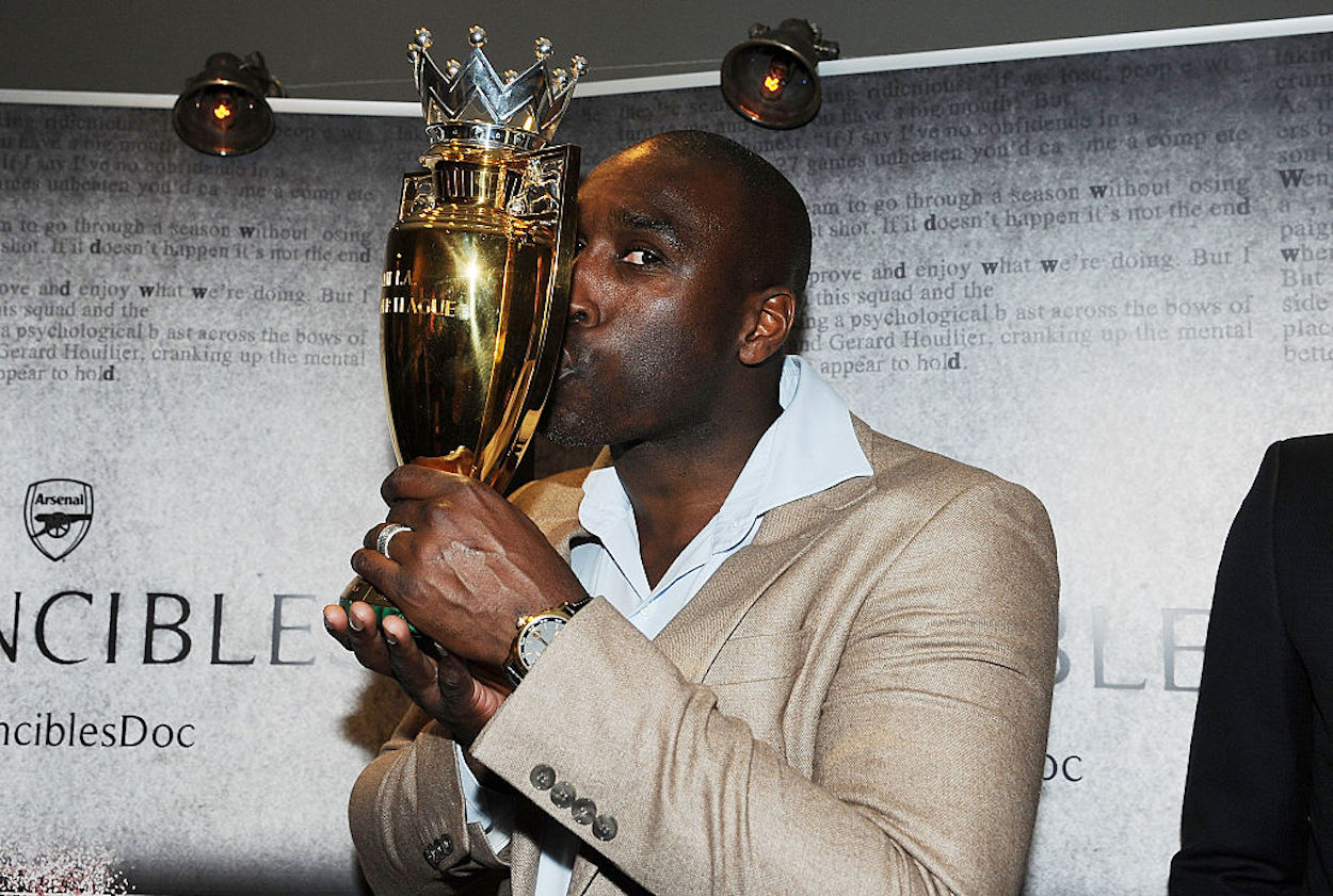 Former Arsenal defender kisses the golden Premier League trophy.