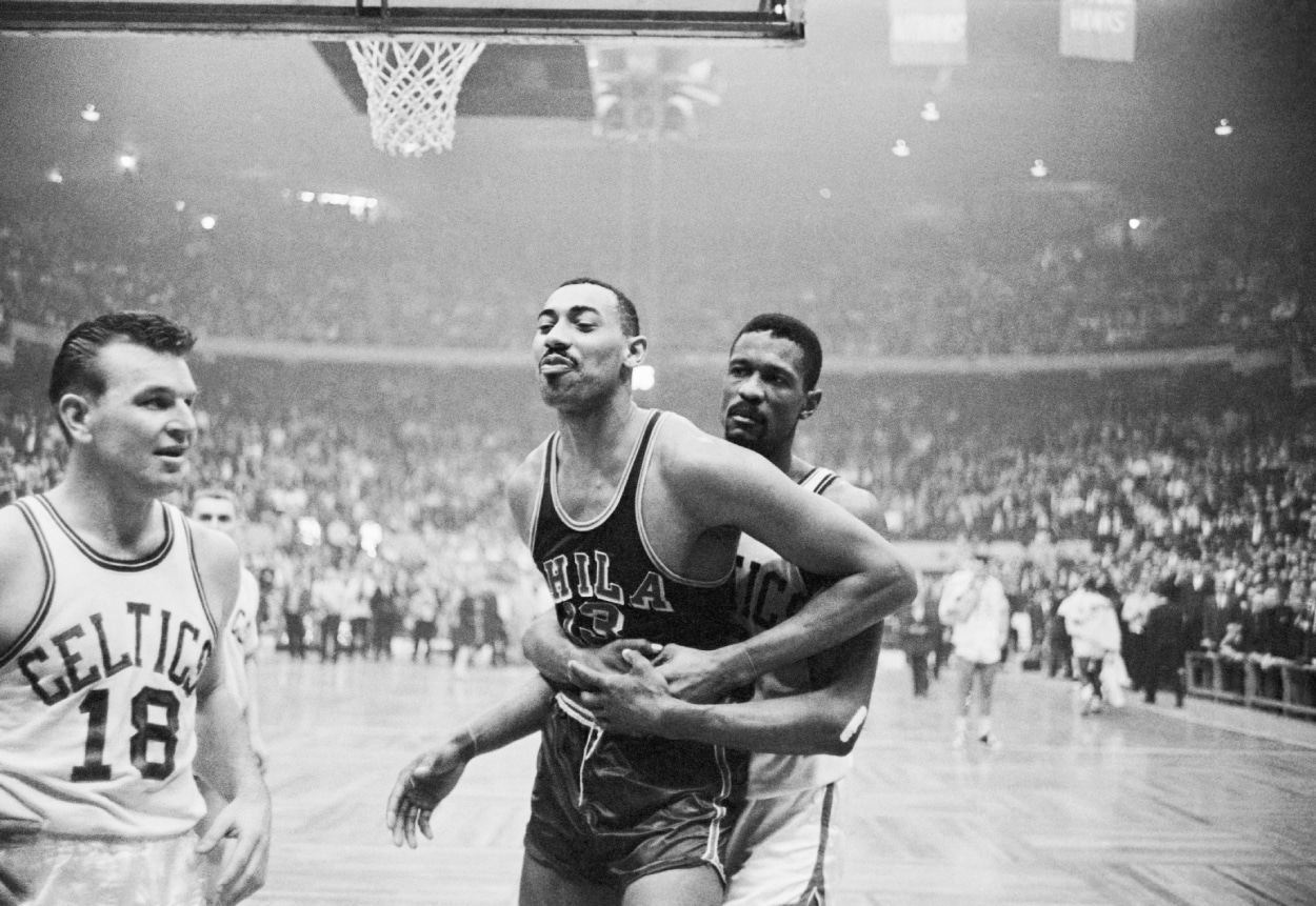 Boston Celtics center Bill Russell holds Wilt Chamberlain back.