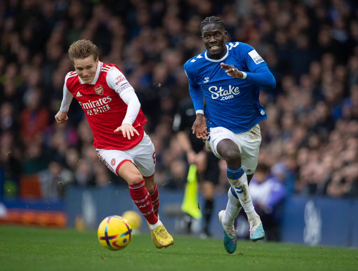 Arsenal's Martin Odegaard (L) and Everton's Amadou Onana battle for the ball during a Premier League match.