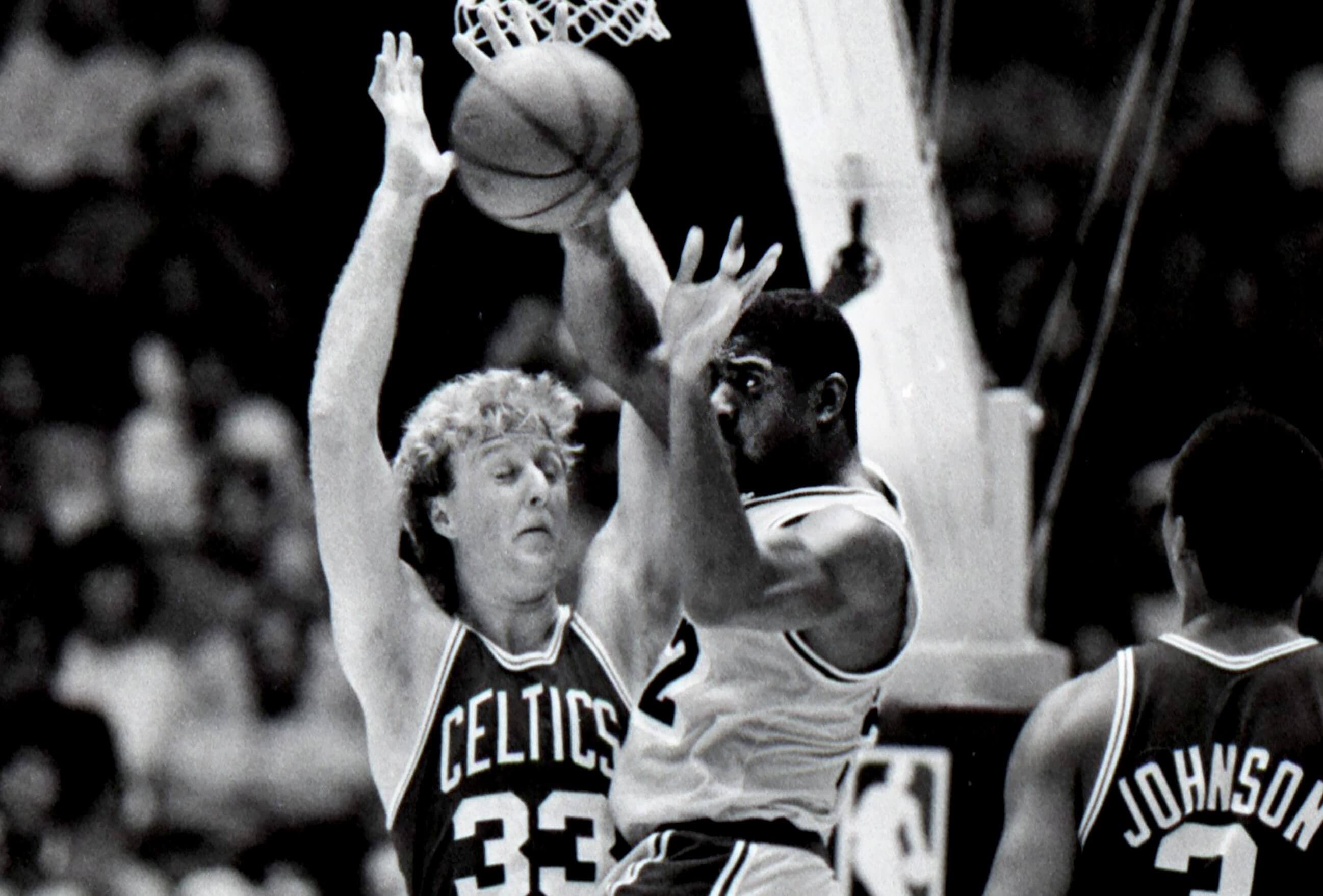 Magic Johnson of the Los Angeles Lakers drives to the basket on Larry Bird.