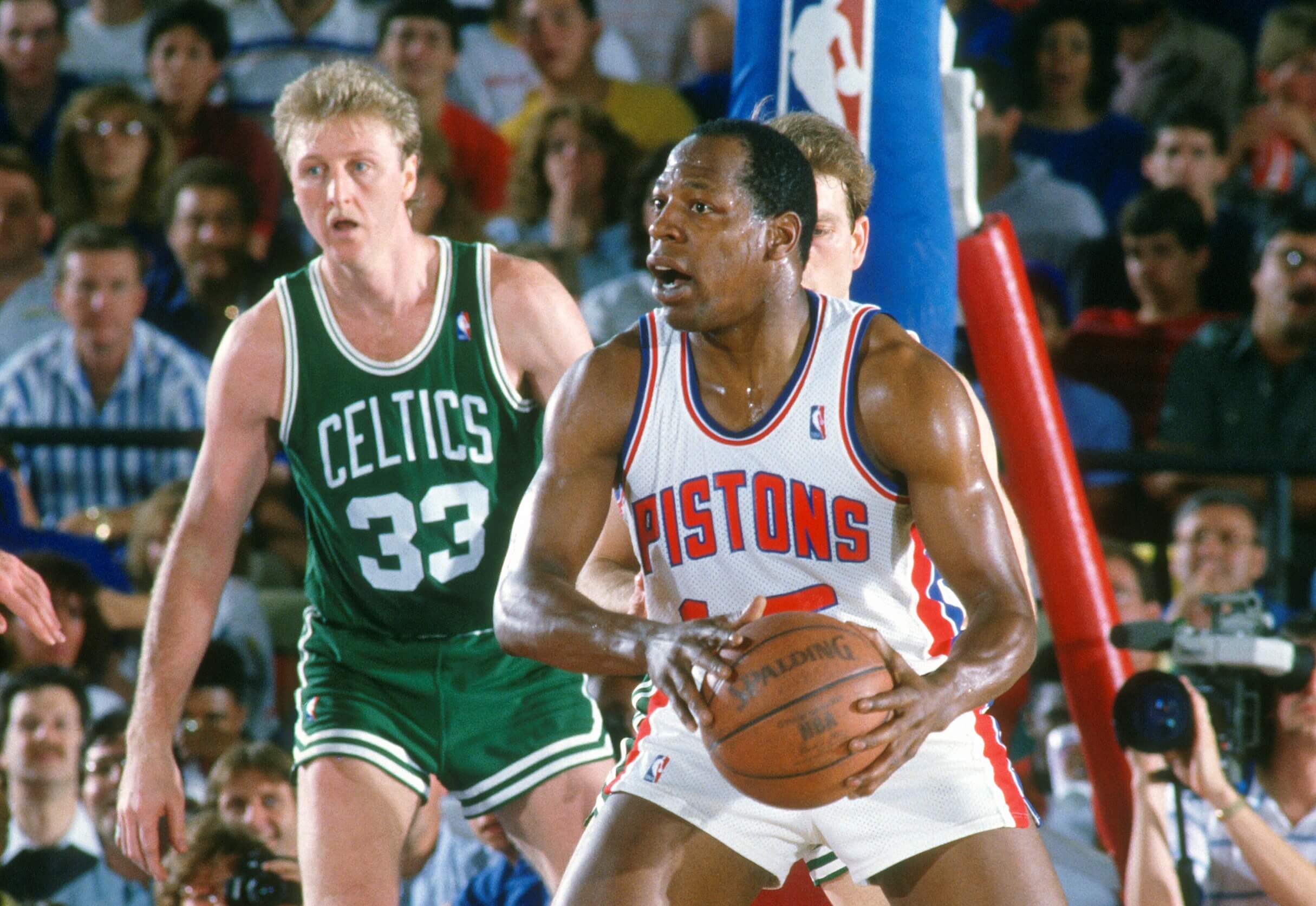 Vinnie Johnson of the Detroit Pistons looks to pass the ball in front of Larry Bird.
