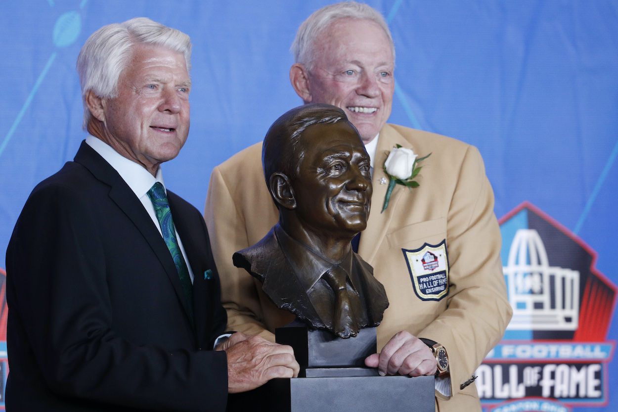 Jimmy Johnson and Jerry Jones pose next to Jones' Hall of Fame bust.