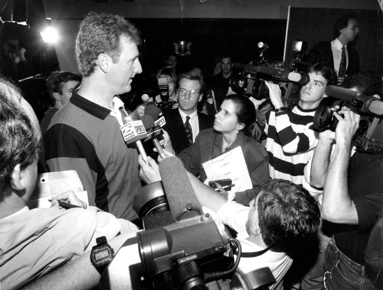 Larry Bird (L) is surrounded by media after announcing his retirement.