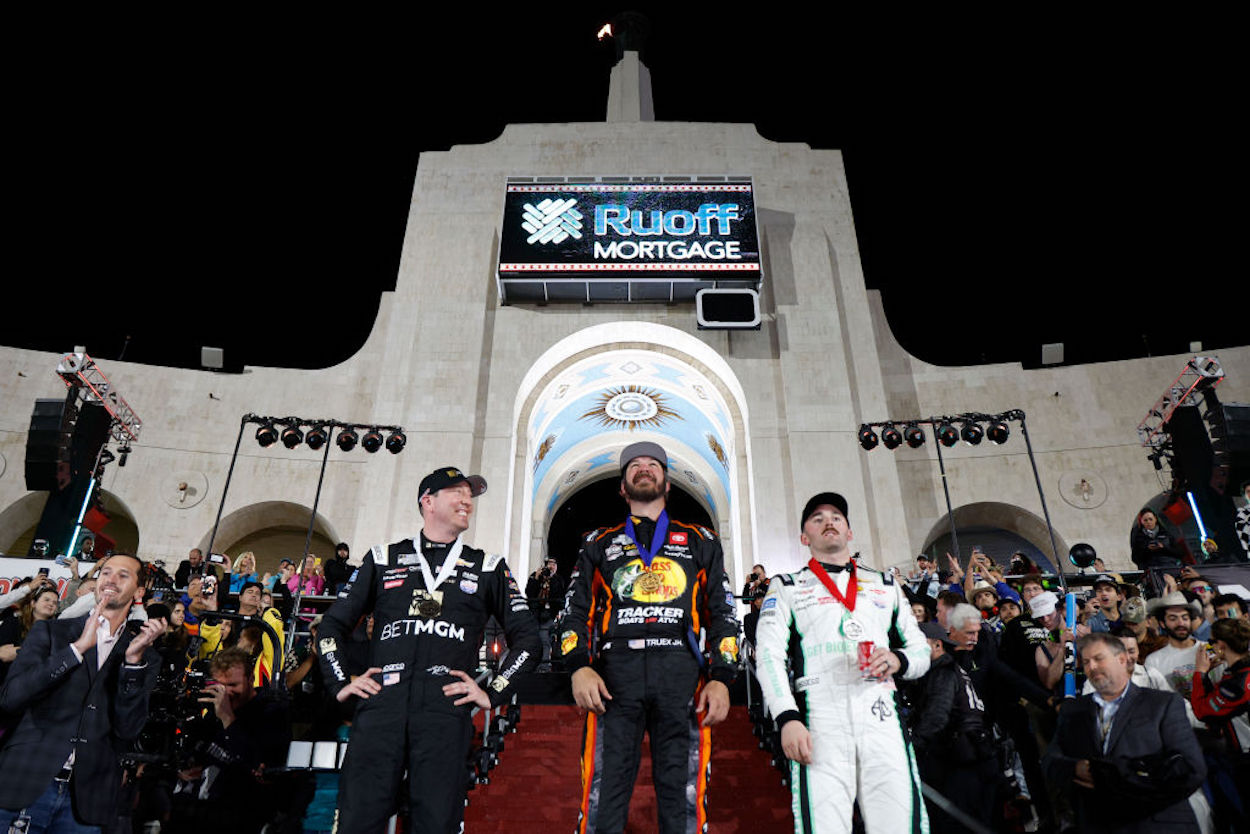 Martin Truex Jr (C), Austin Dillon (R), and Kyle Busch (L) stand on the podium after NASCAR's Clash at the Coliseum.