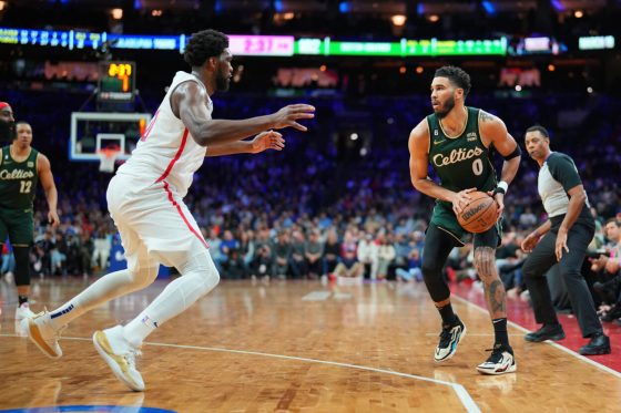 Jayson Tatum of the Boston Celtics controls the ball against Joel Embiid.