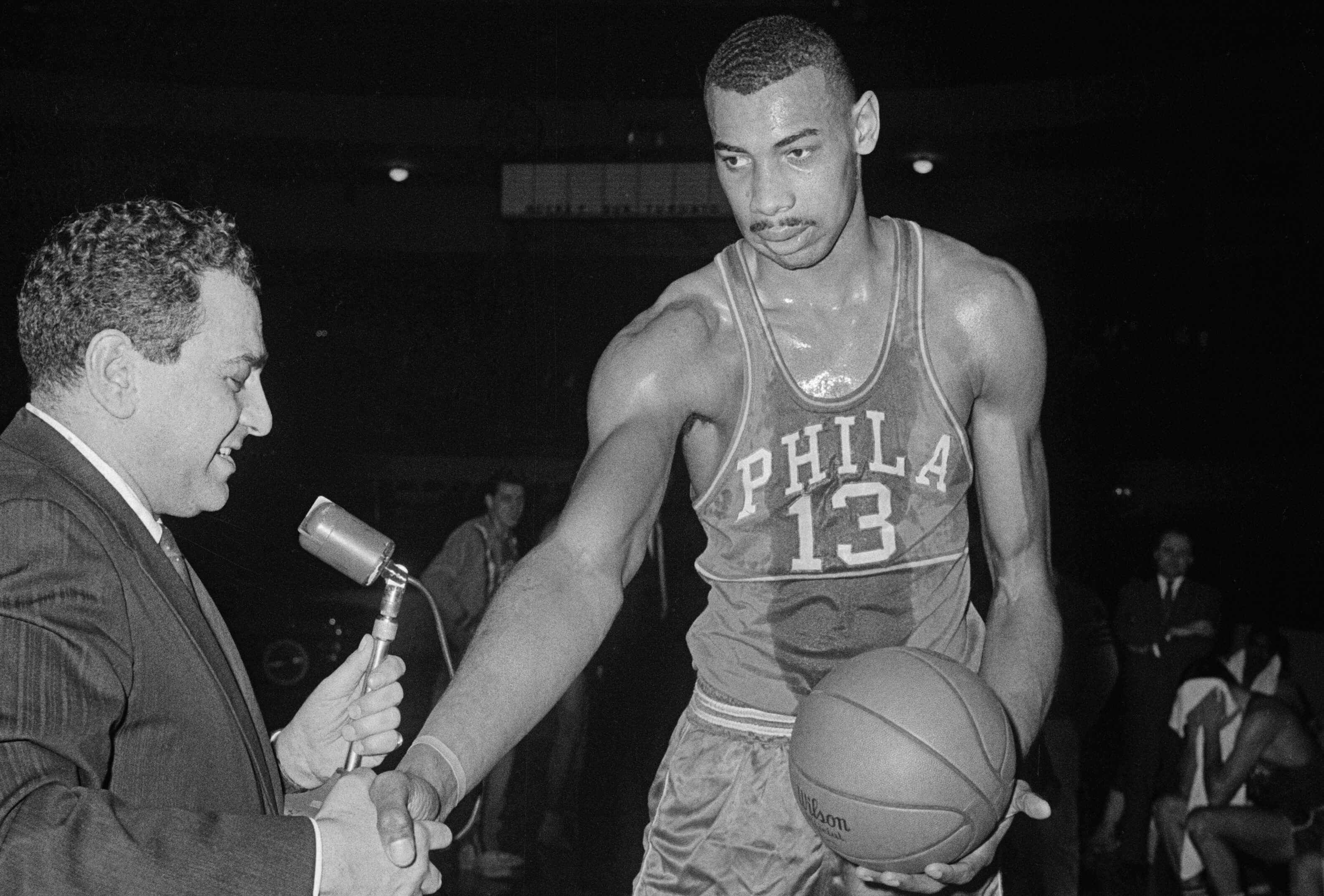 Wilt Chamberlain, of the Philadelphia Warriors, accepts the congratulations of Detroit Pistons General Manager Nick Kerbawy.