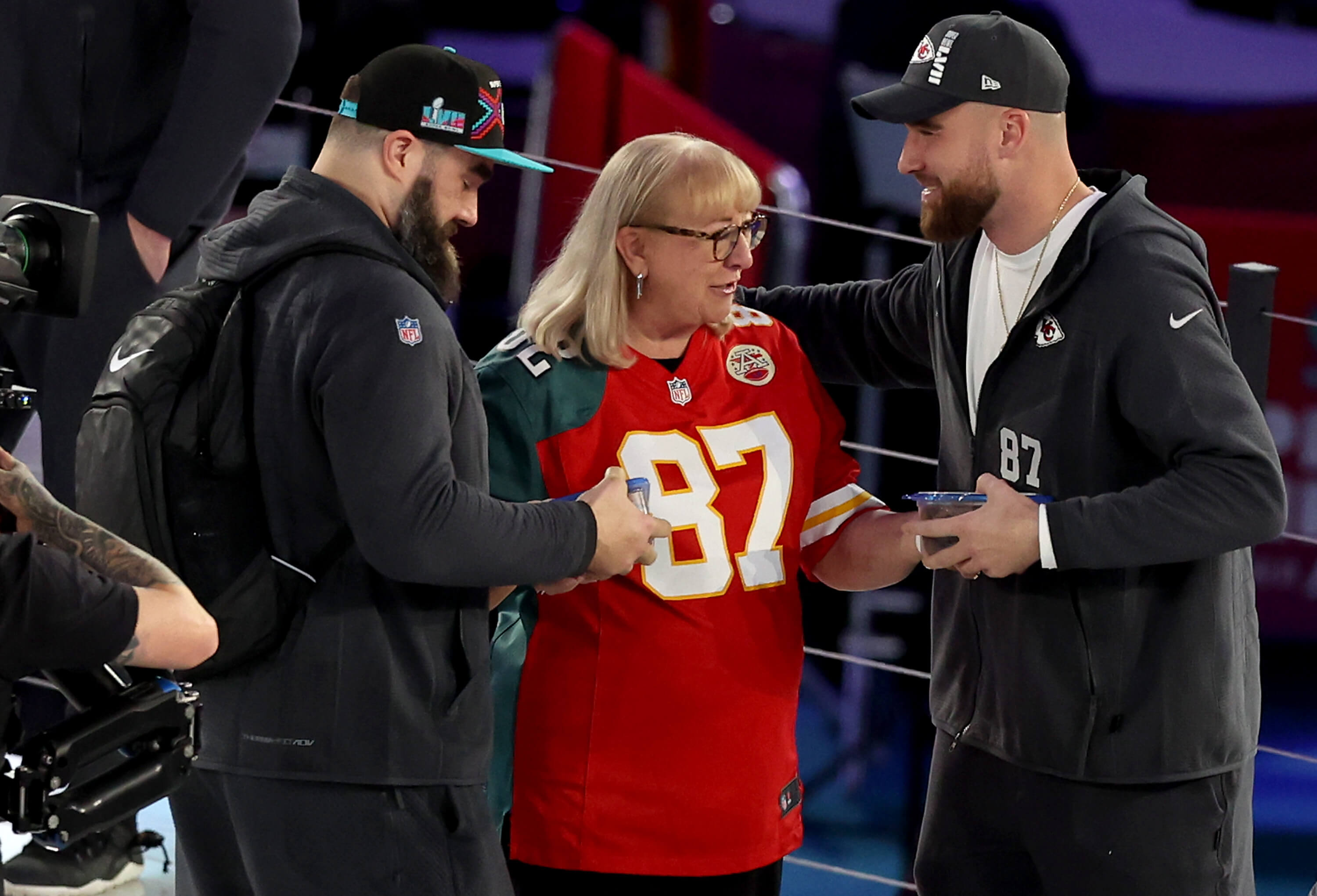 Donna Kelce, center, gives cookies to her sons Jason Kelce, left, of the Philadelphia Eagles and Travis Kelce of the Kansas City Chiefs.