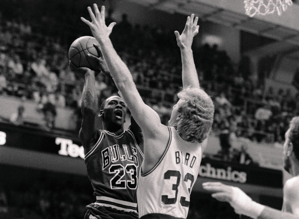Michael Jordan goes up for a basket as Larry Bird attempts to block him.