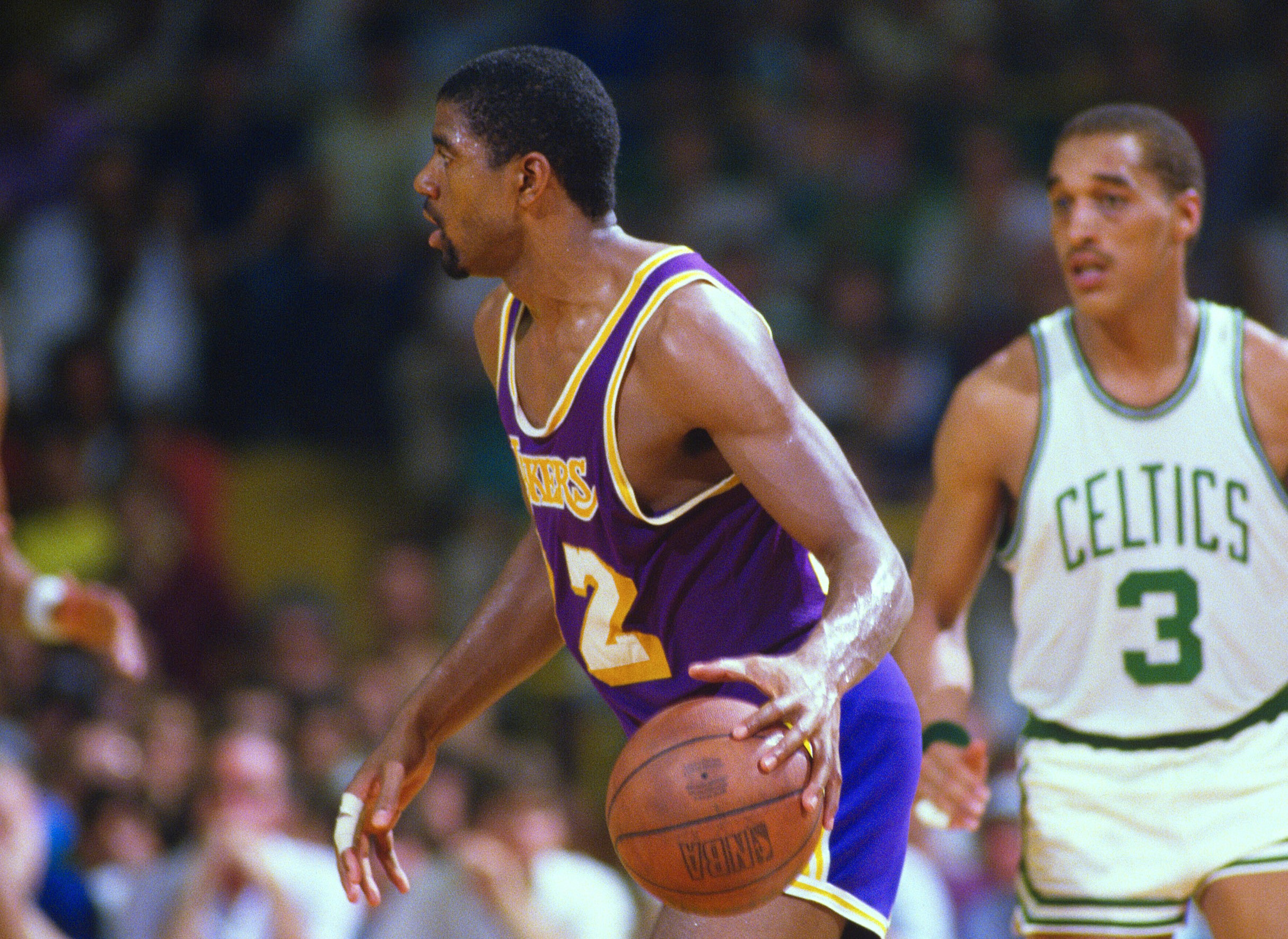 Earvin Magic Johnson of the Los Angeles Lakers dribbles the ball up the court against the Boston Celtics.