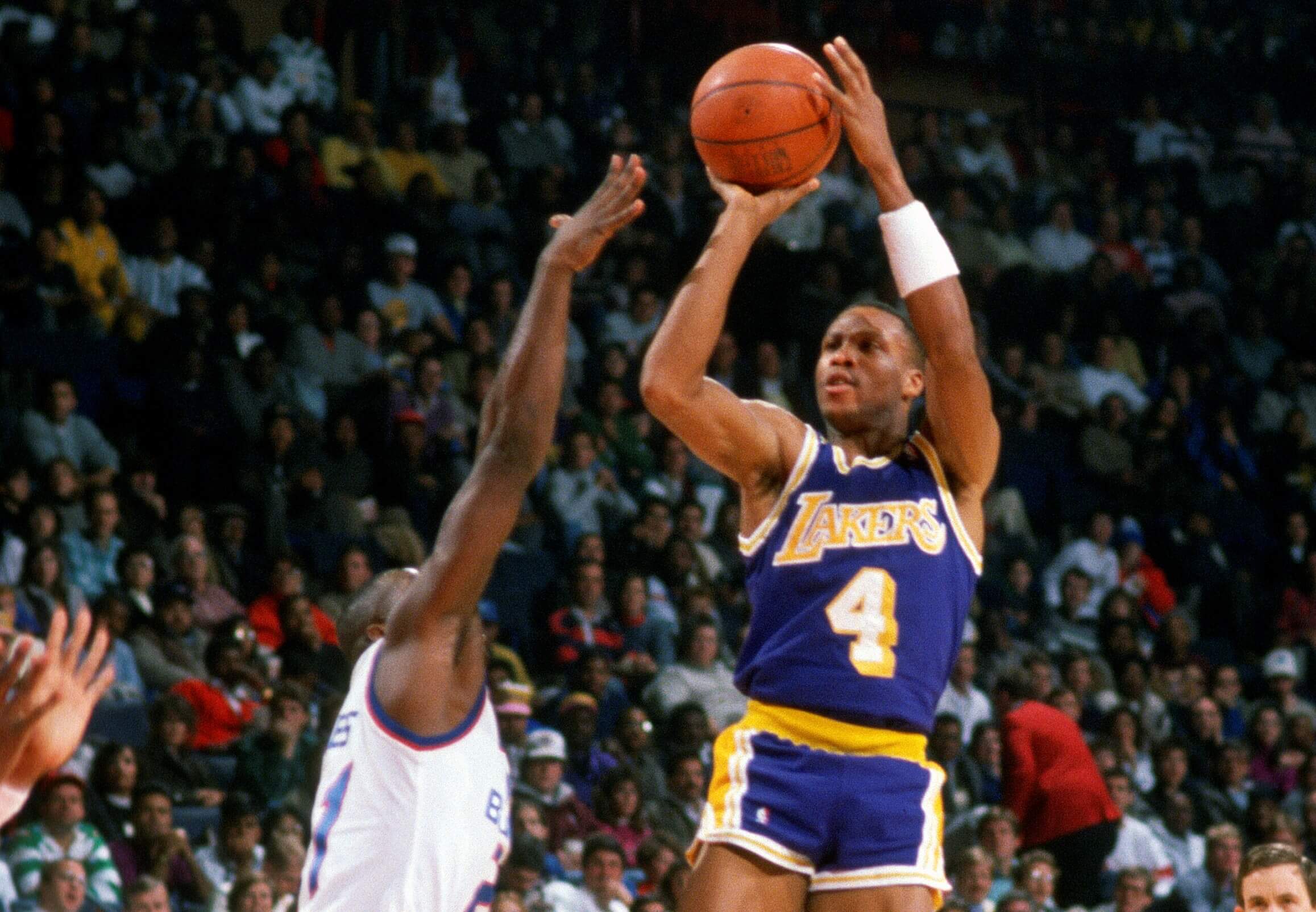 Byron Scott of the Los Angeles Lakers shoots over Ledell Eackles of the Washington Bullets.