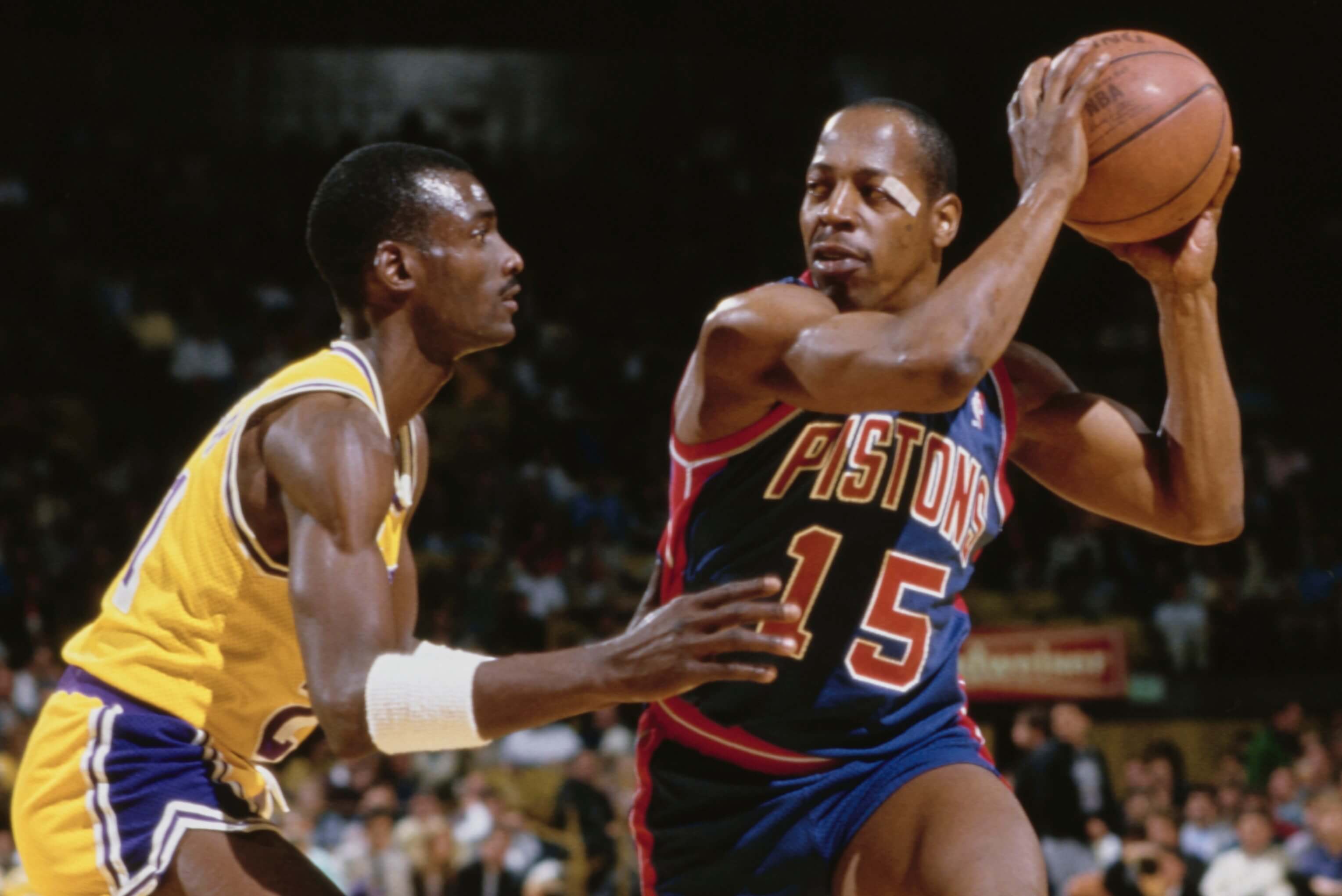 Vinnie Johnson of the Detroit Pistons is guarded by Michael Cooper of the Los Angeles Lakers.