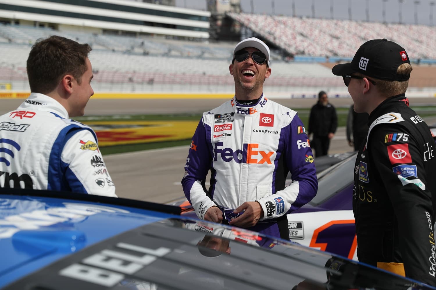 Denny Hamlin, center, shares a laugh with Christopher Bell and Ty Gibbs on the grid during practice for the NASCAR Cup Series Pennzoil 400 at Las Vegas Motor Speedway on March 4, 2023.
