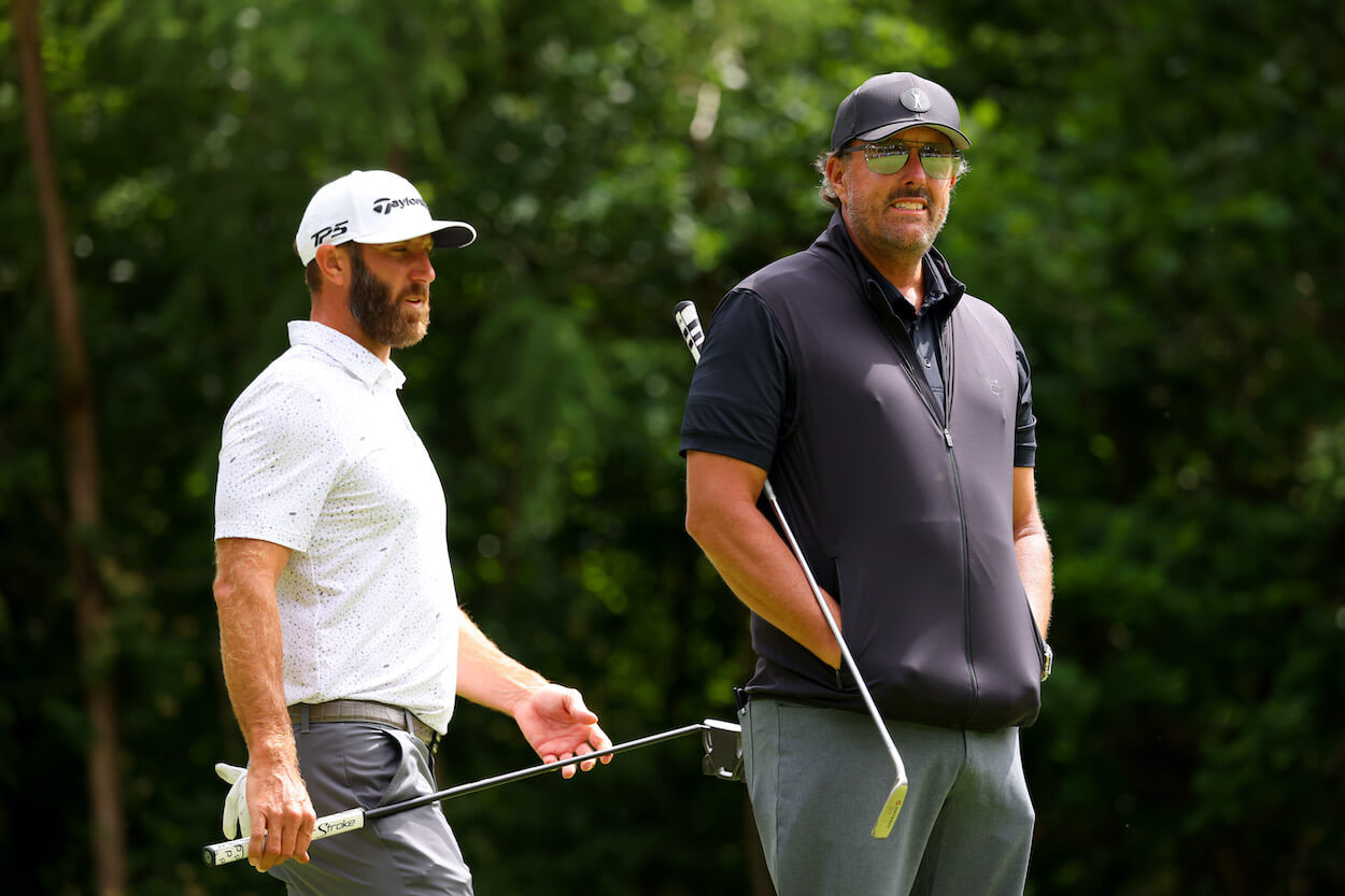Dustin Johnson and Phil Mickelson look on during a LIV Golf event.