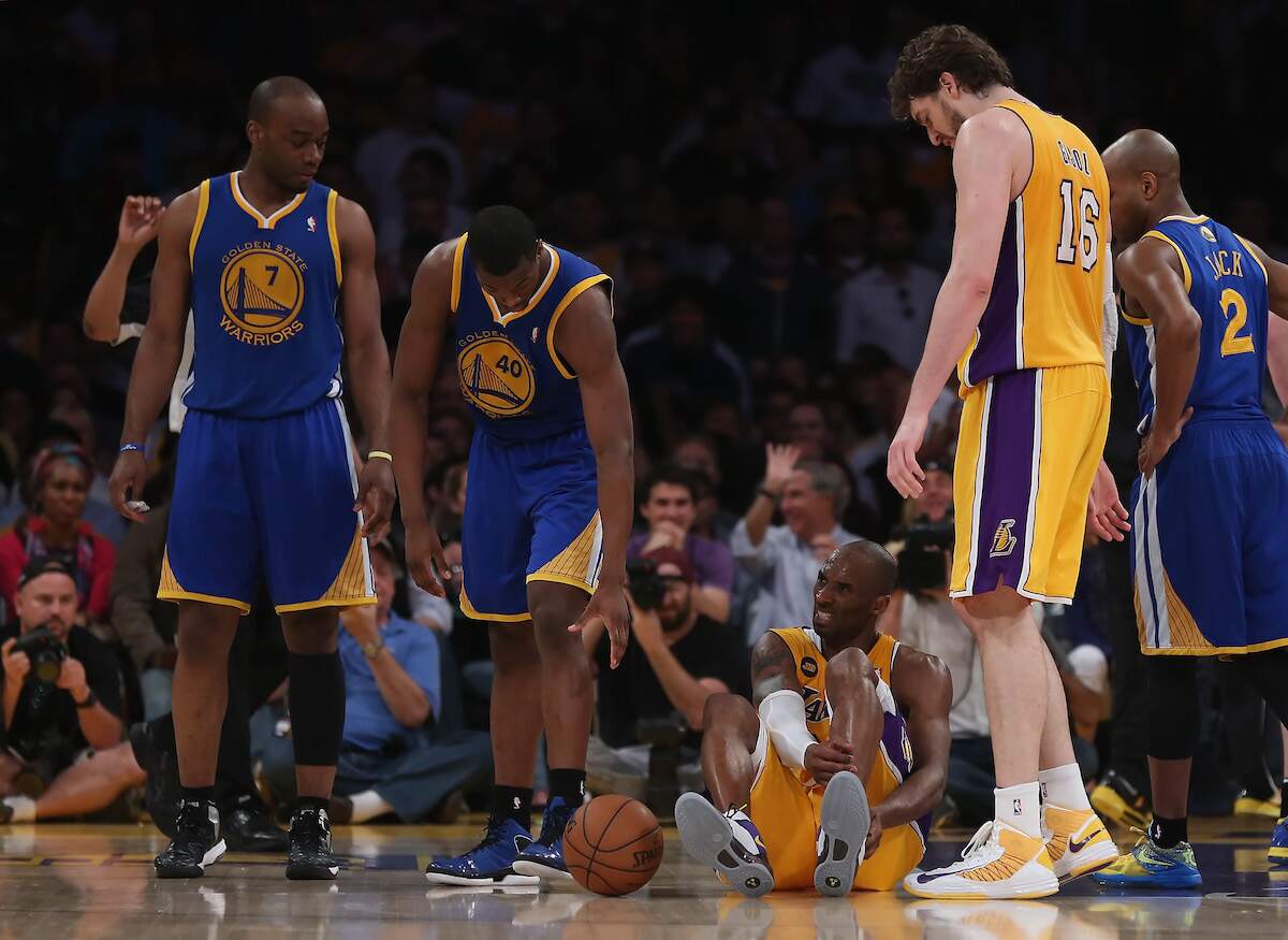 Kobe Bryant of the Los Angeles Lakers grimaces after tearing his Achilles tendon as the Golden State Warriors look on in 2013