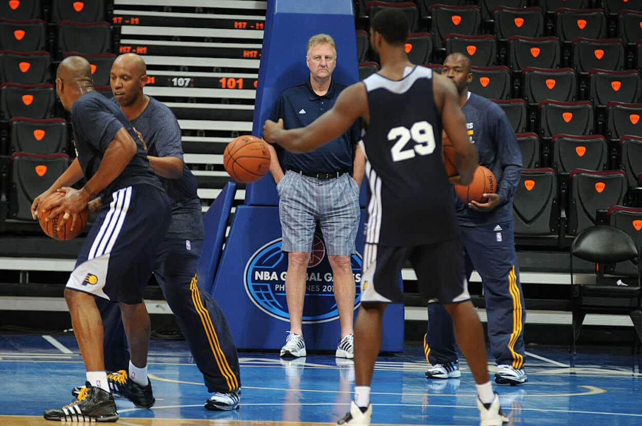 Larry Bird (C) watches the Indiana Pacers warm up.