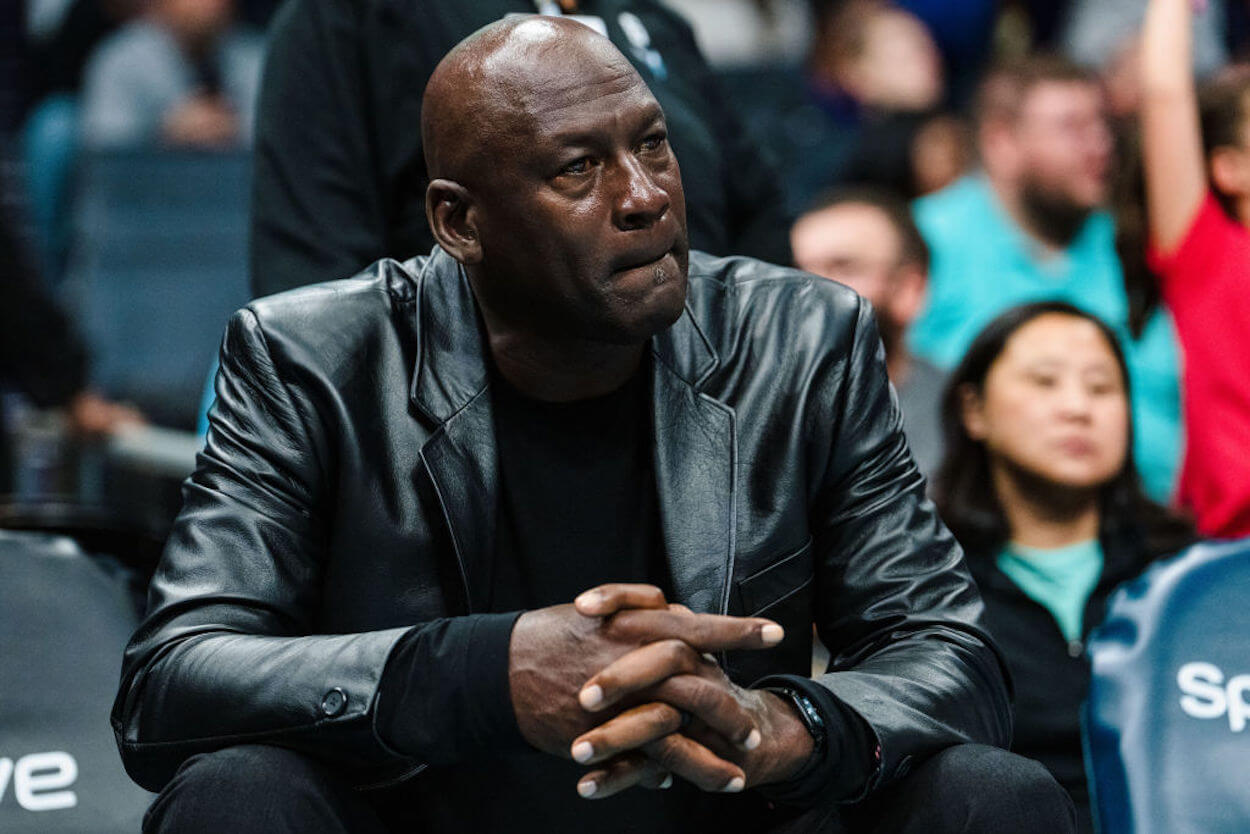 Michael Jordan sits on the sidelines watching his Charlotte Hornets.
