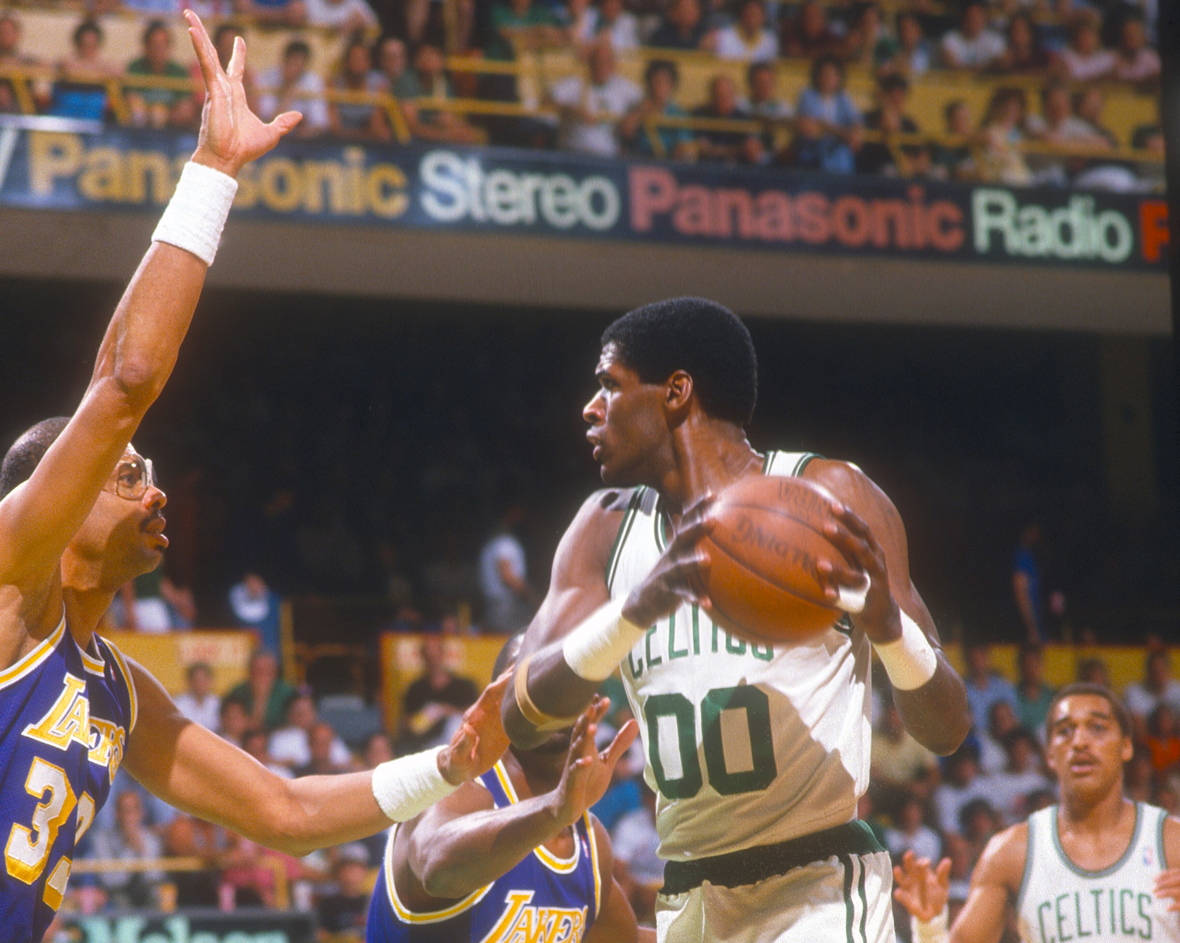 Robert Parish of the Boston Celtics looks to pass the ball over Kareem Abdul-Jabbar.