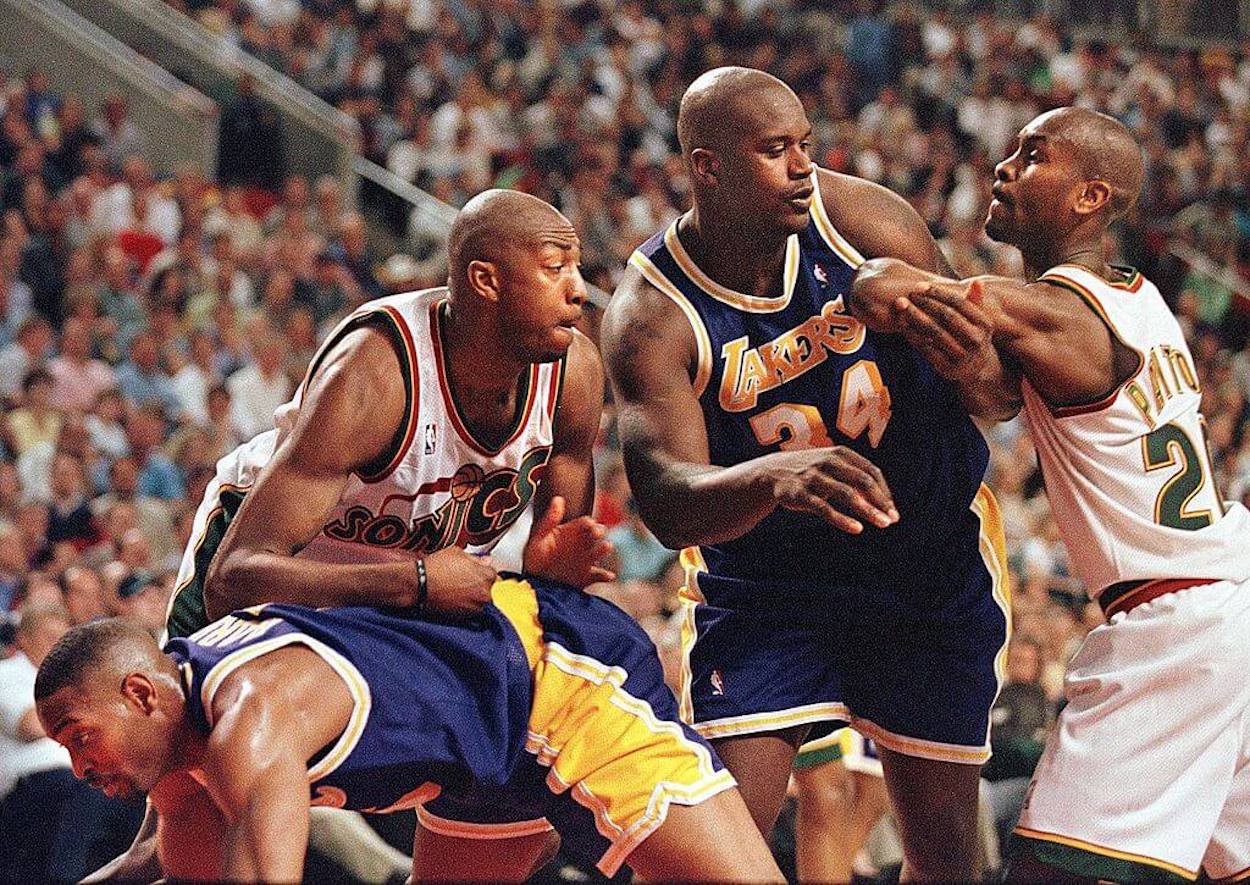 Shaquille O'Neal (C) and Gary Payton (R) get into it physically during an NBA game.