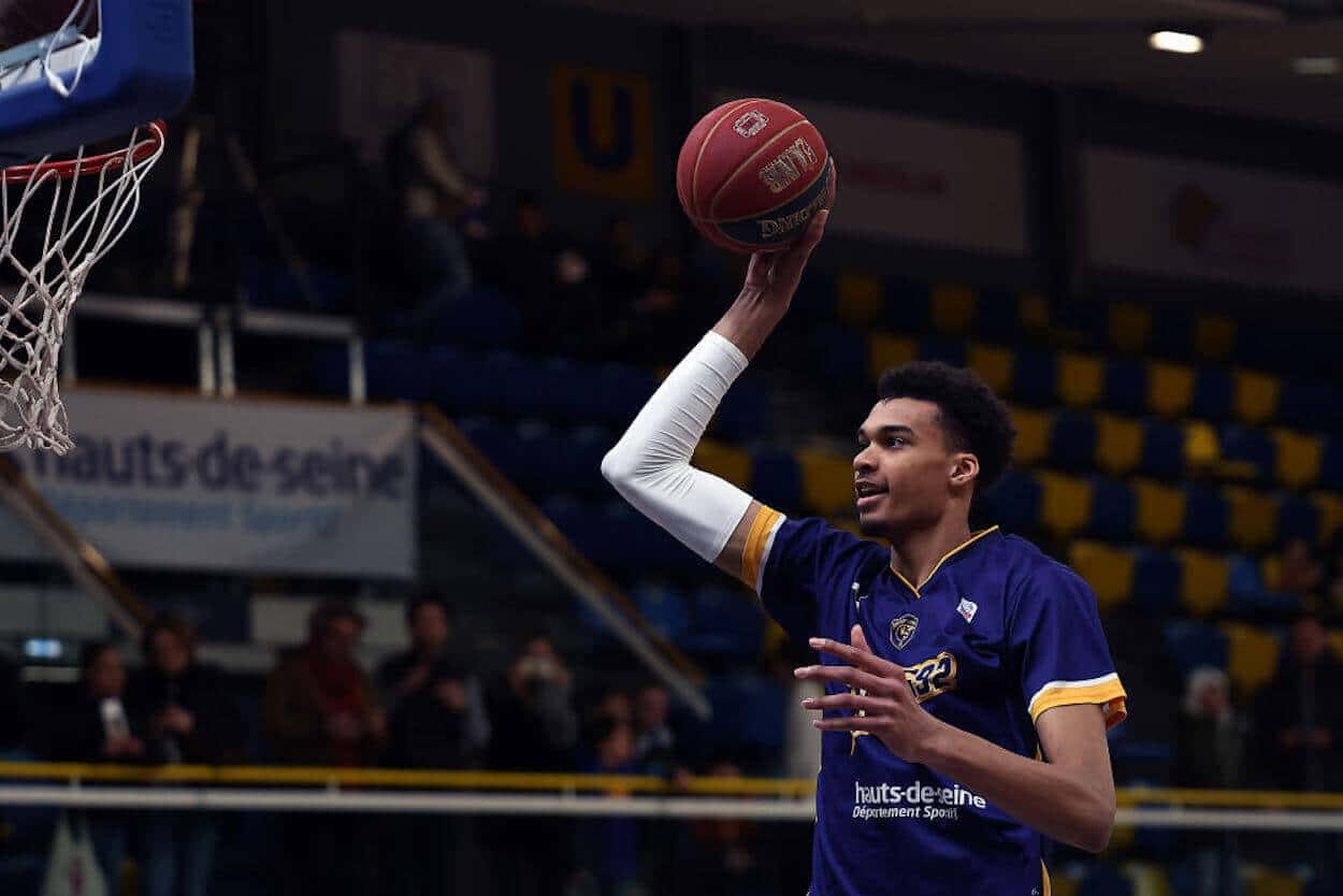 Victor Wembanyama dunks a ball during warmups.