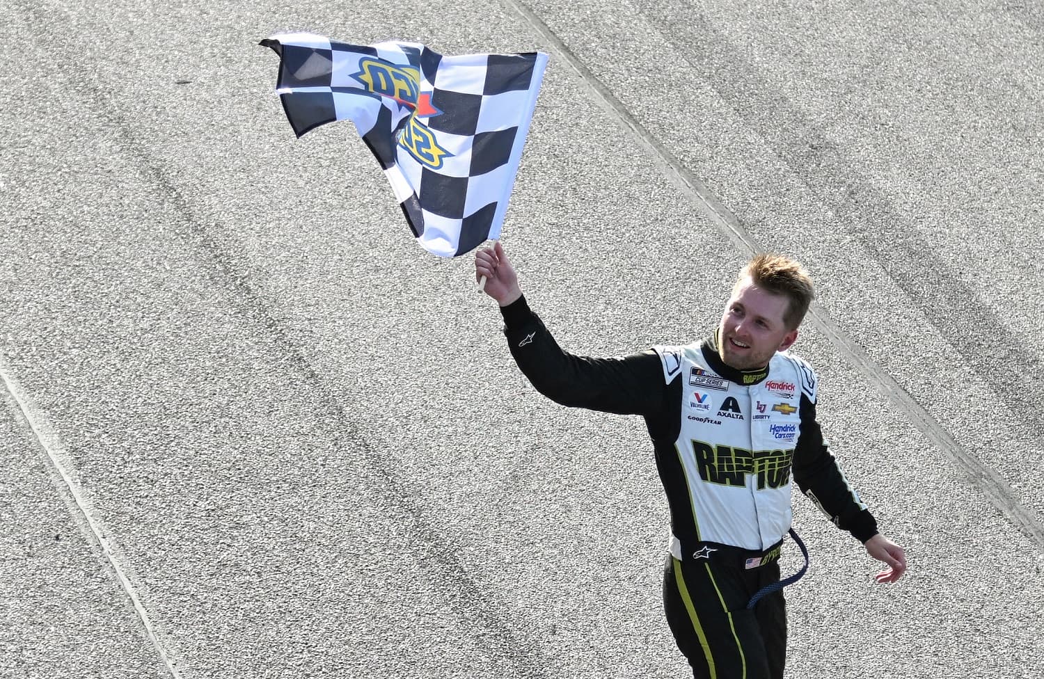 William Byron celebrates with the checkered flag after winning the NASCAR Cup Series Goodyear 400 at Darlington Raceway on May 14, 2023.