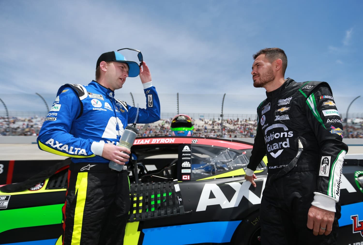 William Byron and Kyle Larson talk on the grid at the NASCAR Cup Series Drydene 400 at Dover International Speedway on May 16, 2021.