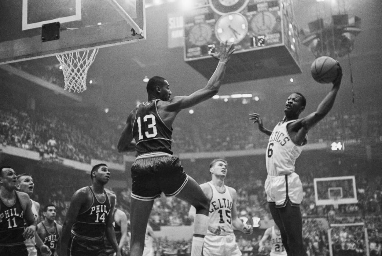 Wilt Chamberlain goes up to block Bill Russell's shot.