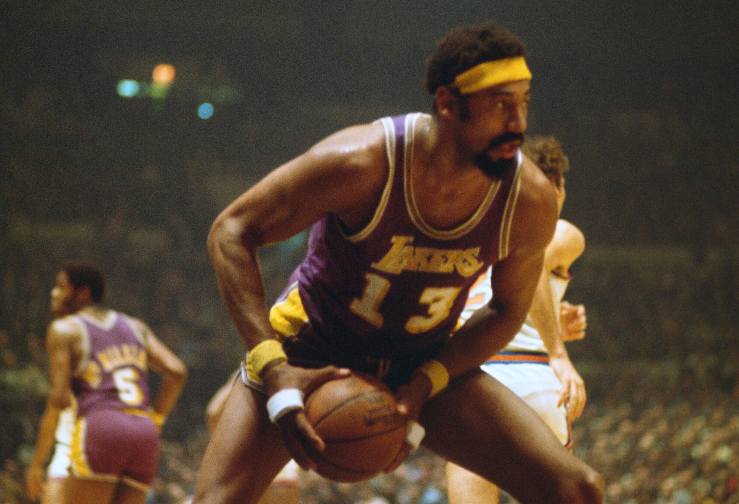 Wilt Chamberlain of the Los Angeles Lakers pulls down a rebound.