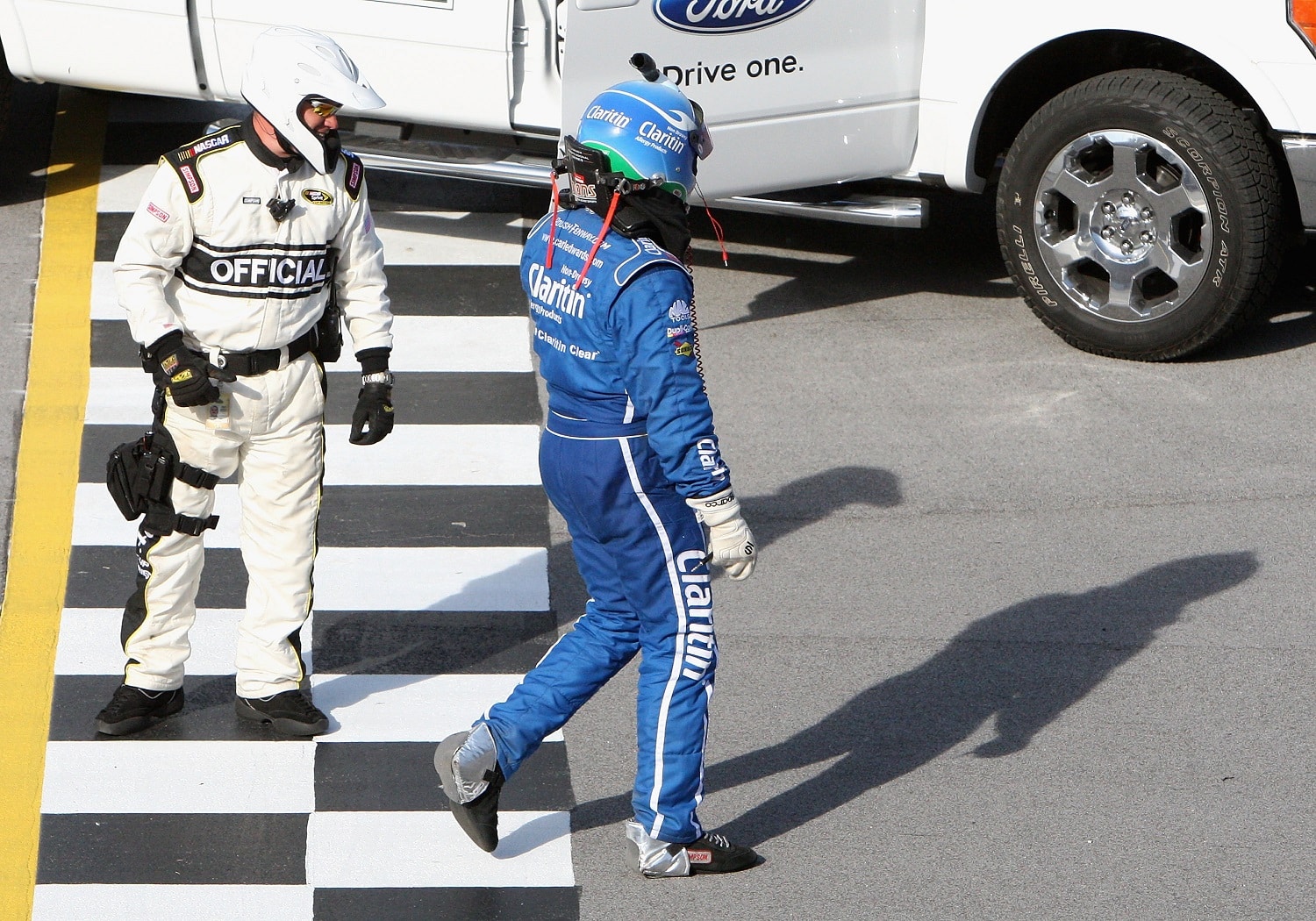 Carl Edwards walks across the finish line after wrecking during the final lap of the Aaron's 499 at Talladega Superspeedway on April 26, 2009 in Talladega, Alabama. | Christian Petersen/Getty Images