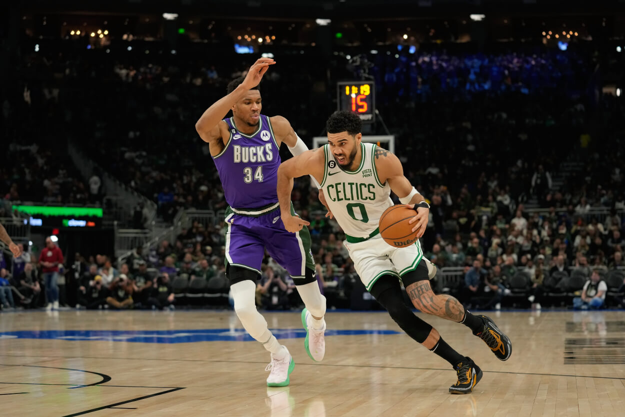 Jayson Tatum of the Boston Celtics dribbles the ball against Giannis Antetokounmpo of the Milwaukee Bucks.