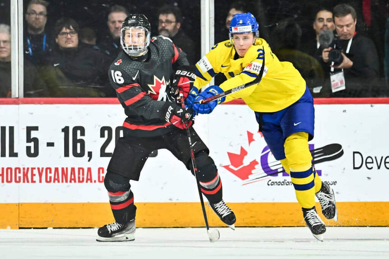 Connor Bedard (L) battles for a puck during World Juniors.