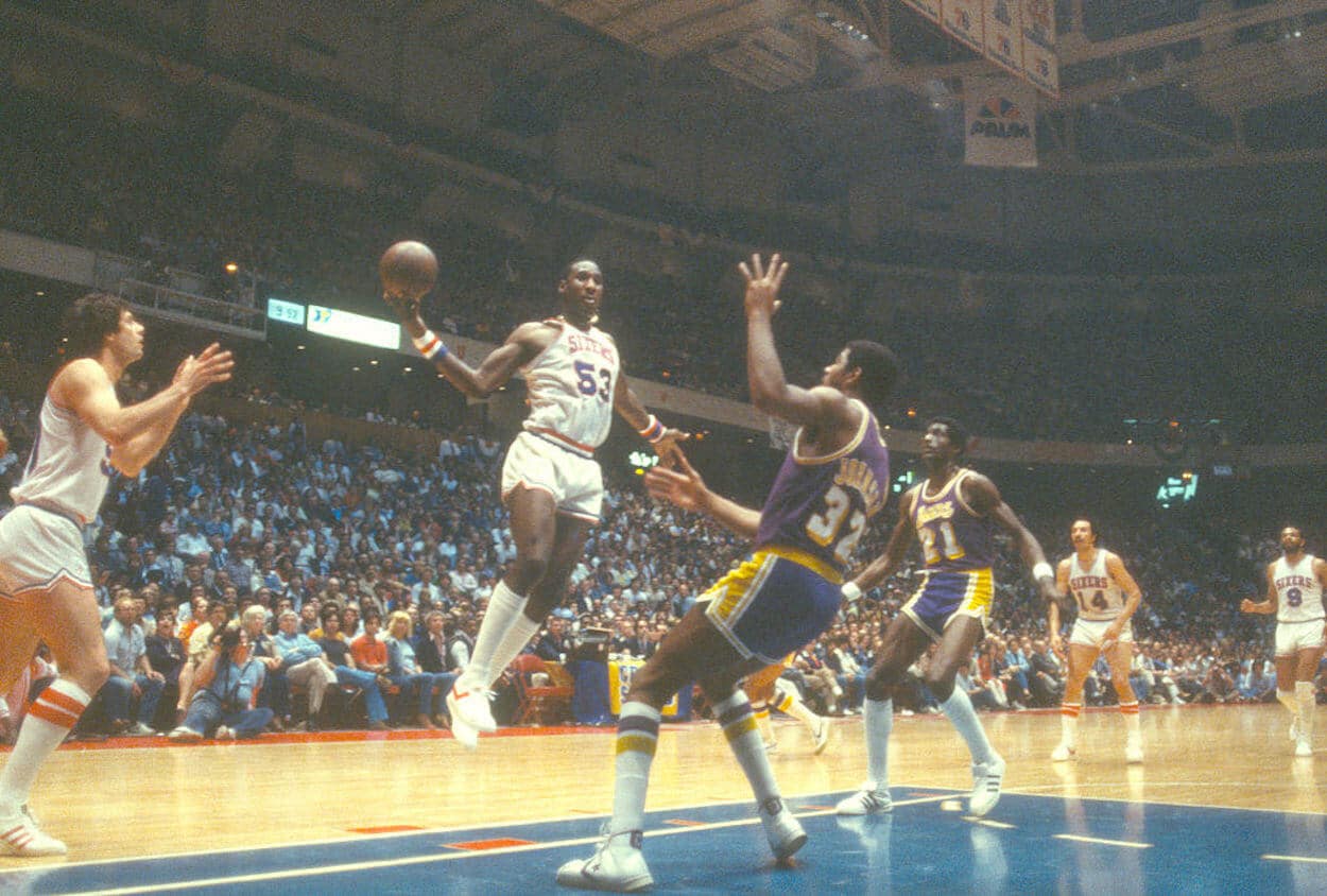 Darryl Dawkins (L) goes up for a shot over Magic Johnson (R)