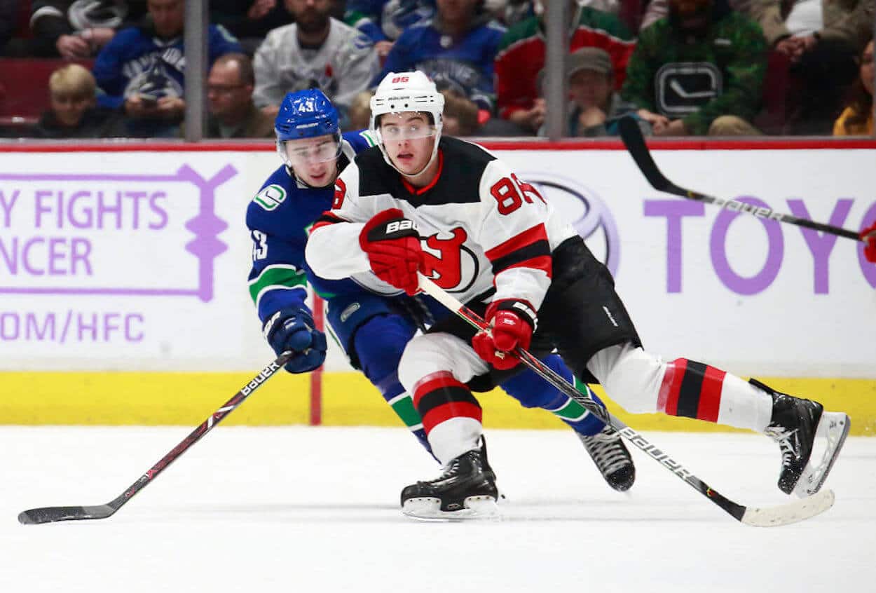 Jack Hughes (R) and Quinn Hughes (L) go head-to-head in NHL action.