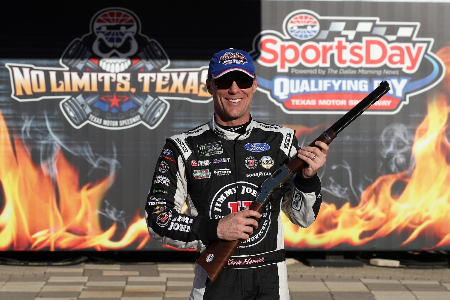 Kevin Harvick poses with the Henry repeating rifle pole award in Victory Lane after qualifying for pole position for the Monster Energy NASCAR Cup Series O'Reilly Auto Parts 500 at Texas Motor Speedway on April 7, 2017. } Chris Graythen/Getty Images