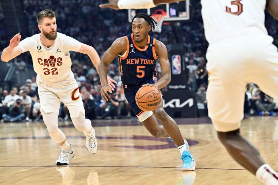Immanuel Quickley drives to the basket against the Cleveland Cavaliers. A No. 19 band, honoring Willis Reed, can be seen on his shoulder.