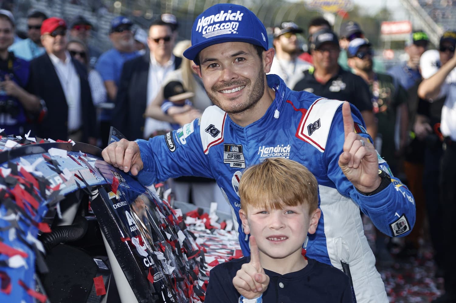 Kyle Larson and son Owen pose next to his winner sticker on his car after winning the NASCAR Cup Series NOCO 400 at Martinsville Speedway on April 16, 2023.
