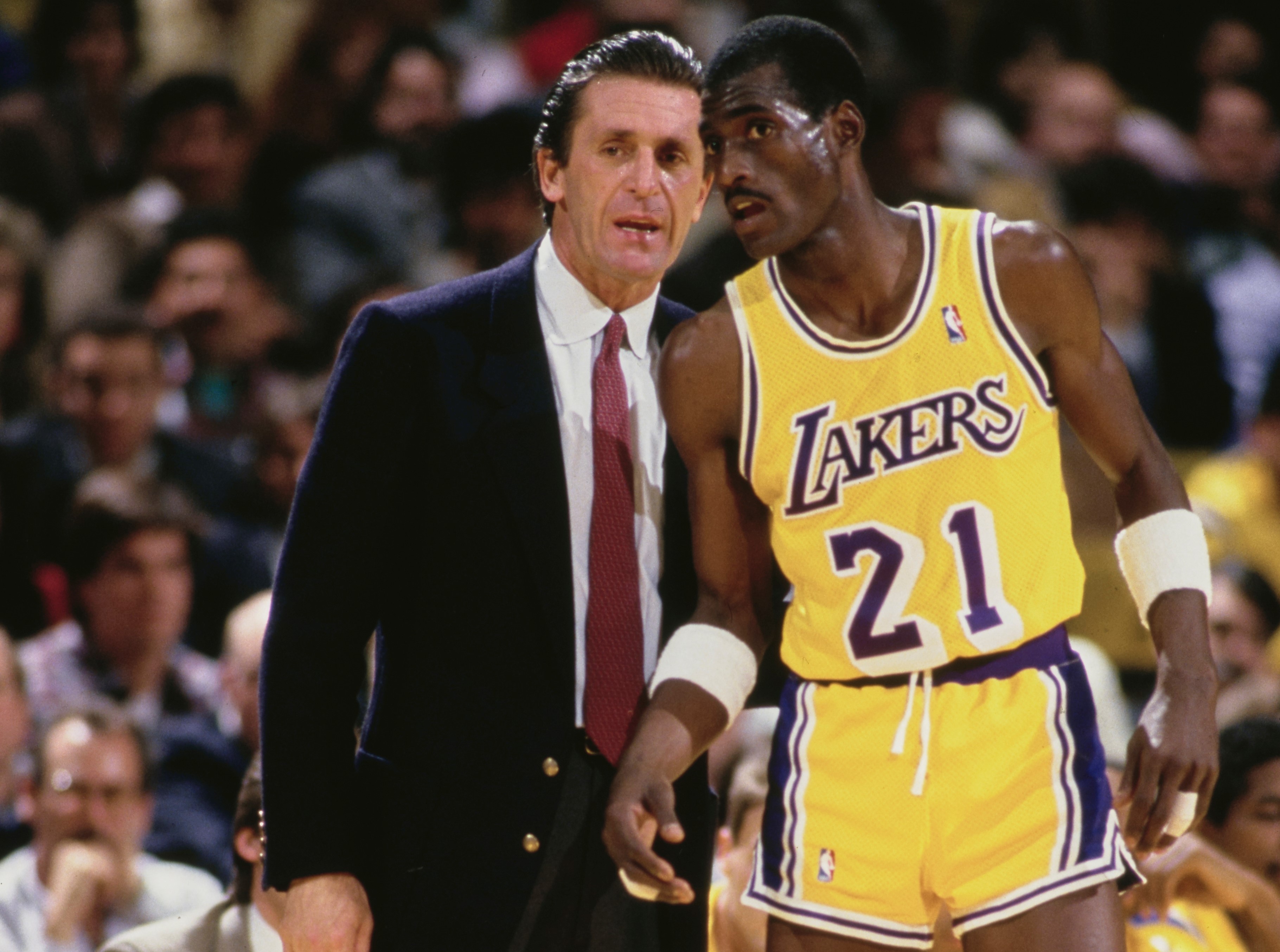Michael Cooper of the Los Angeles Lakers listens to instructions from head coach Pat Riley.