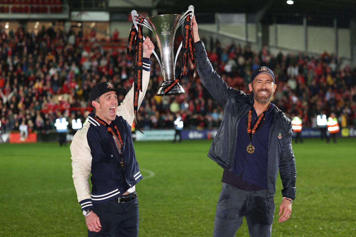 Rob McElhenney and Ryan Reynolds lift the trophy after Wrexham AFC's promotion back to the Football League.