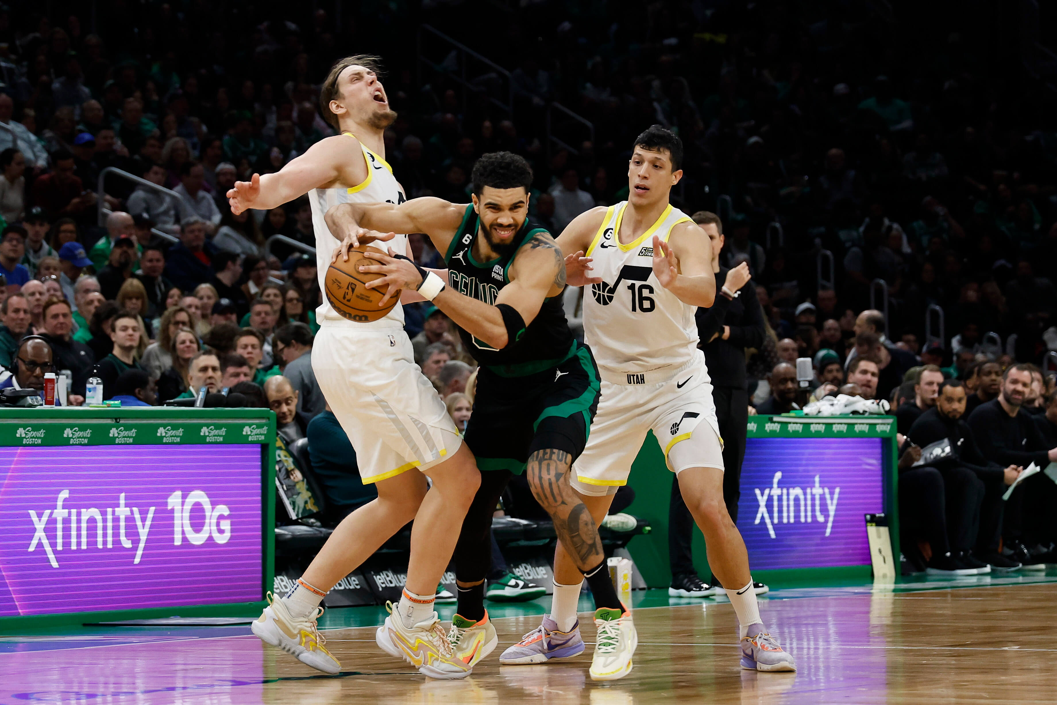 Jayson Tatum of the Boston Celtics tries to escape the double team of Simone Fontecchio #16 of the Utah Jazz and Kelly Olynyk.