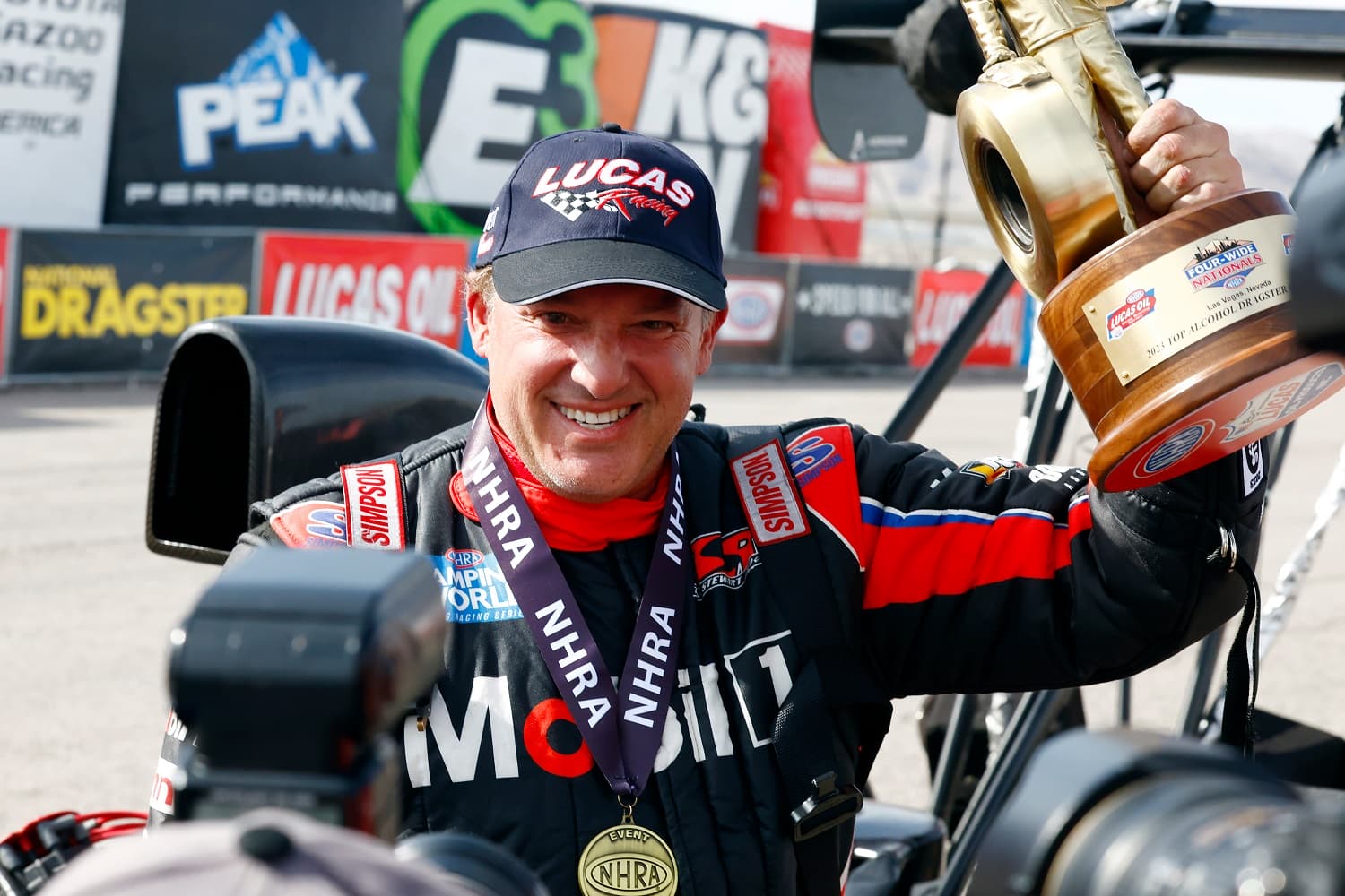 Tony Stewart holds up his Wally trophy and celebrates after winning his class at the NHRA Four-Wide Nationals on April 16, 2023 at Las Vegas Motor Speedway.