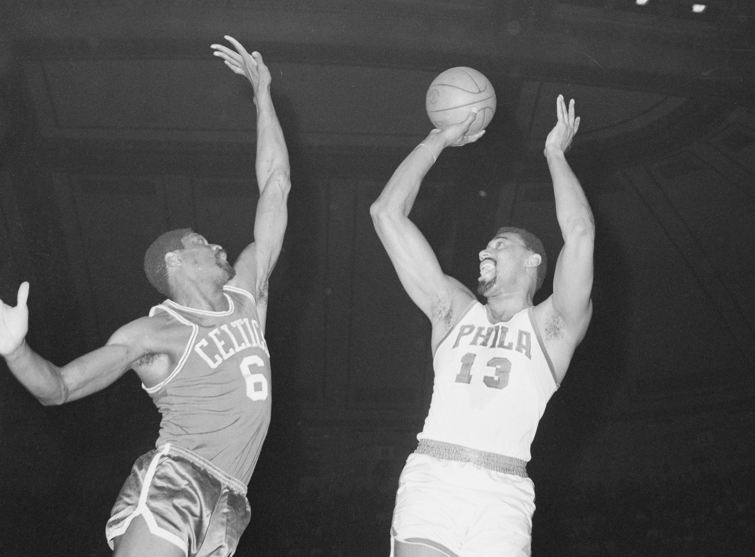 Wilt Chamberlain takes a shot over Bill Russell.