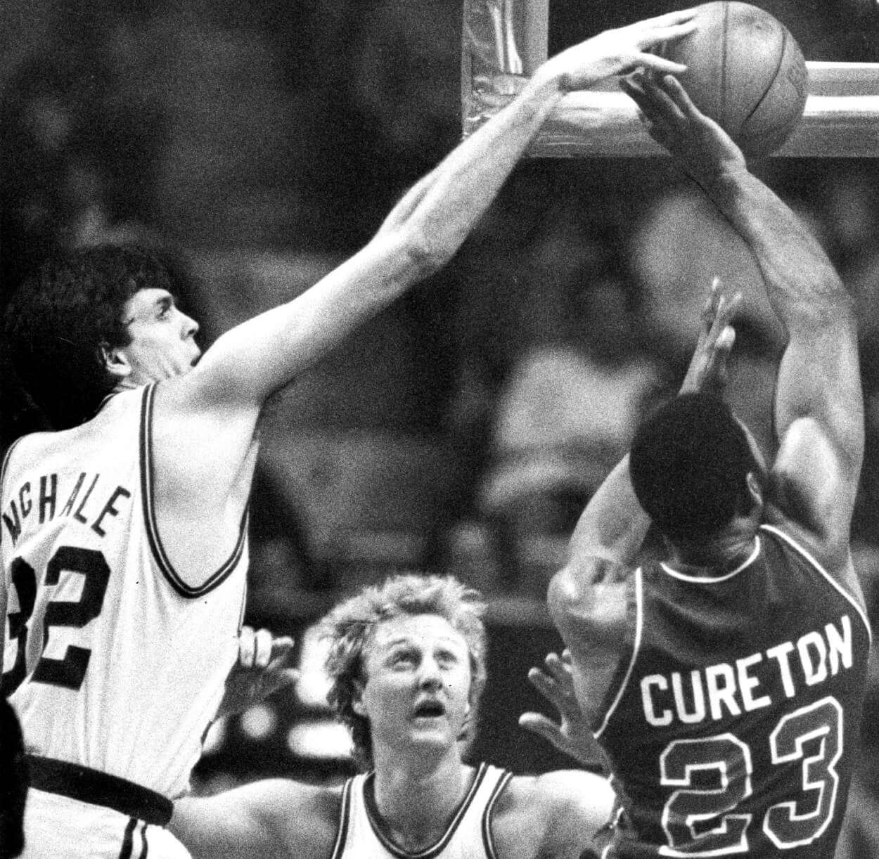 Boston Celtics forward Kevin McHale blocks a shot by Detroit's Earl Cureton, with Boston's Larry Bird between them.