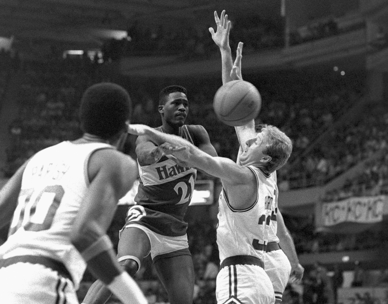 Atlanta Hawks star Dominique Wilkins passes off as Boston Celtics forward Larry Bird guards closely.