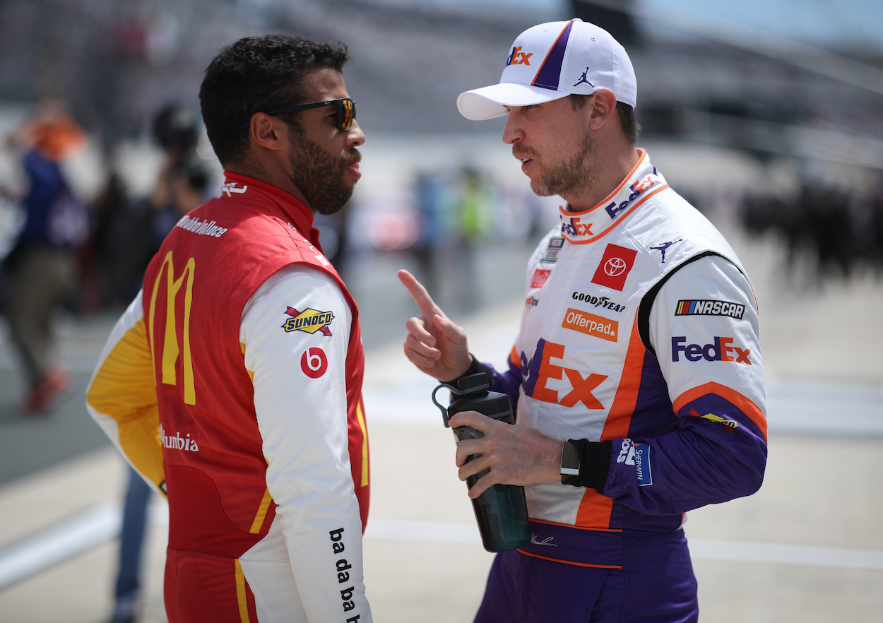 Bubba Wallace and Denny Hamlin talk on the grid during the NASCAR Cup Series Drydene 400 at Dover International Speedway on May 16, 2021. | Sean Gardner/Getty Images