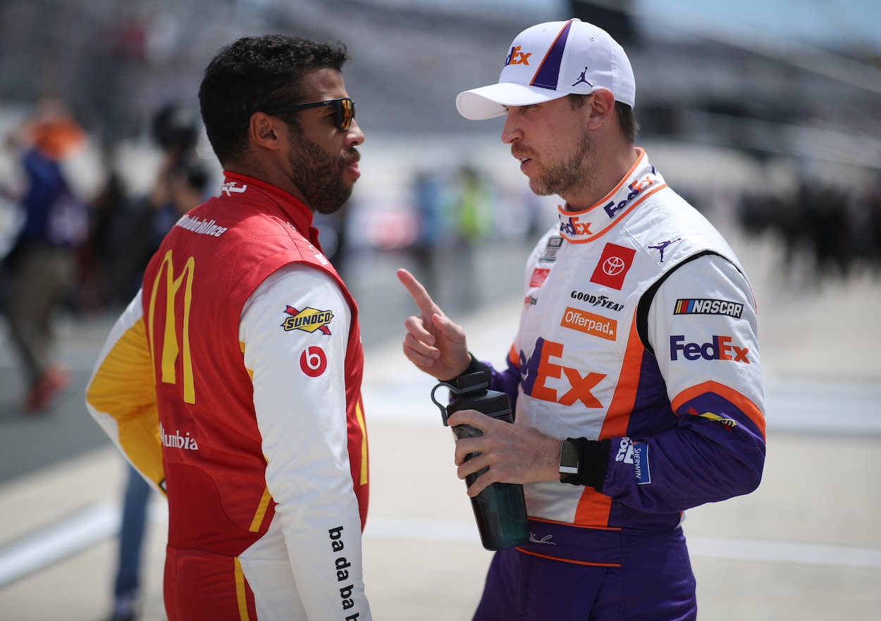 Bubba Wallace and Denny Hamlin talk on the grid during the NASCAR Cup Series Drydene 400 at Dover International Speedway on May 16, 2021. | Sean Gardner/Getty Images