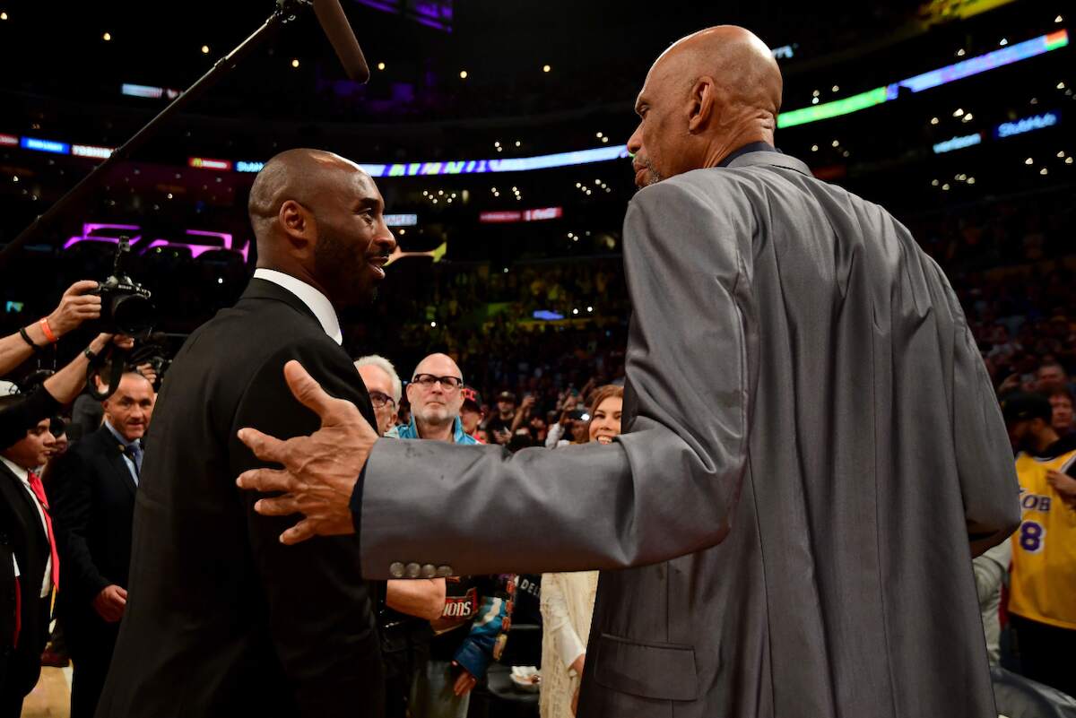 Kareem Abdul-Jabbar pats Kobe Bryant on the back at Bryant's Lakers jersey retirement ceremony in 2017