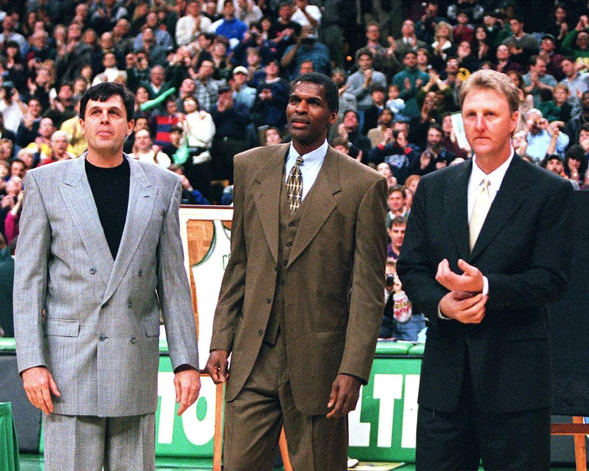 Kevin McHale, Robert Parish, and Larry Bird stand together at TD Garden during a ceremony for retiring Parish's number (00)
